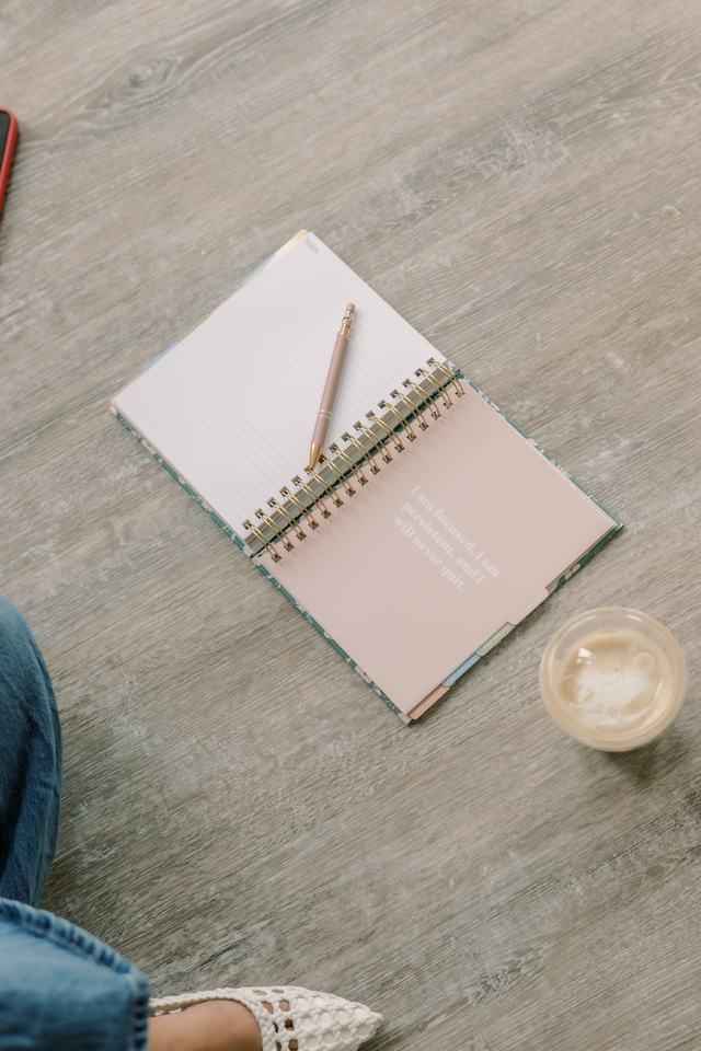 An open notebook, pen, and iced coffee ready for a discovery call