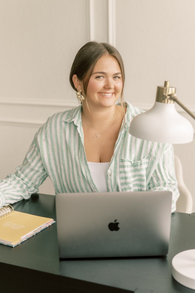 Elsie smiling at her desk with her laptop and planner